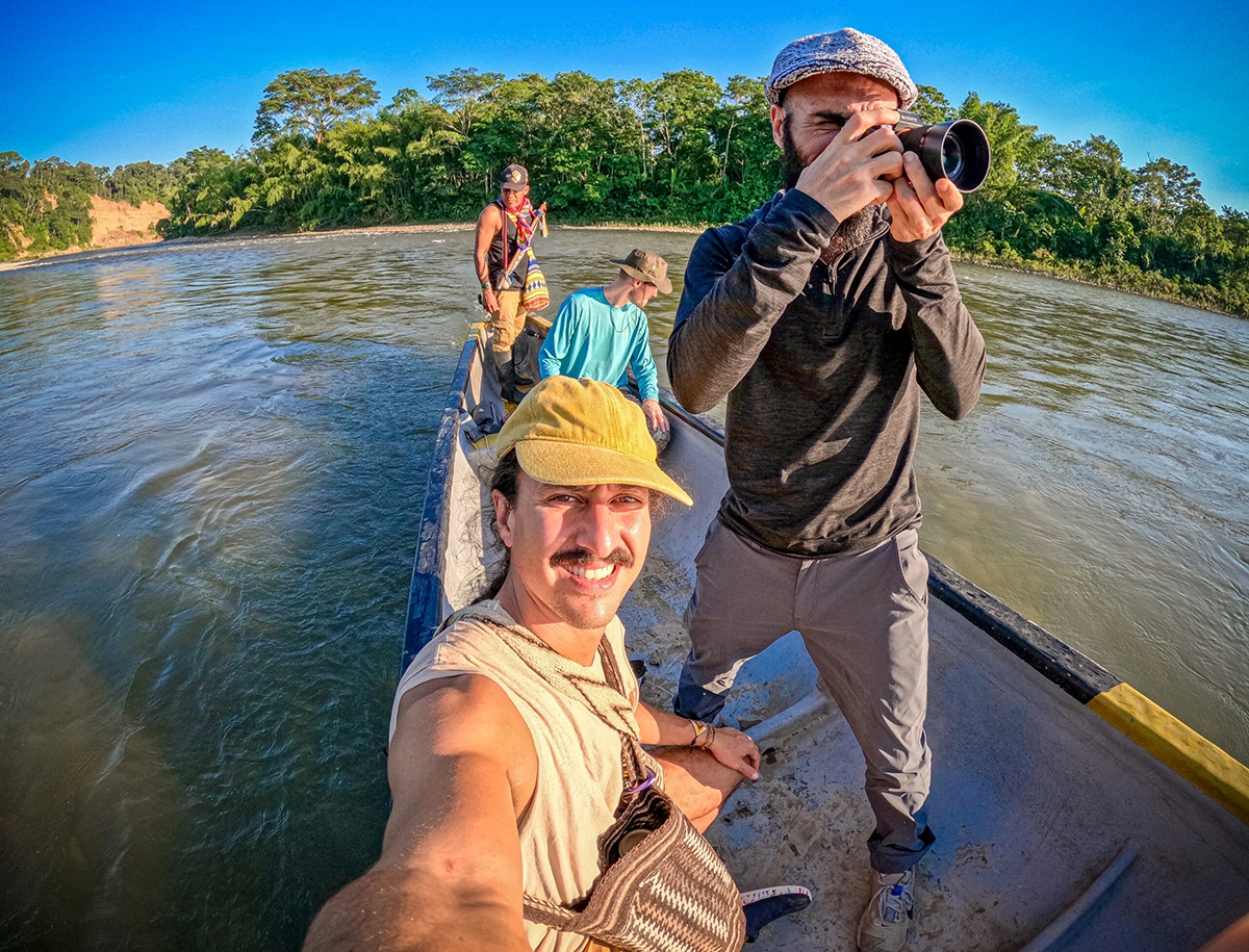Jose traveling by boat along the river with Lucho, a Kofán guide